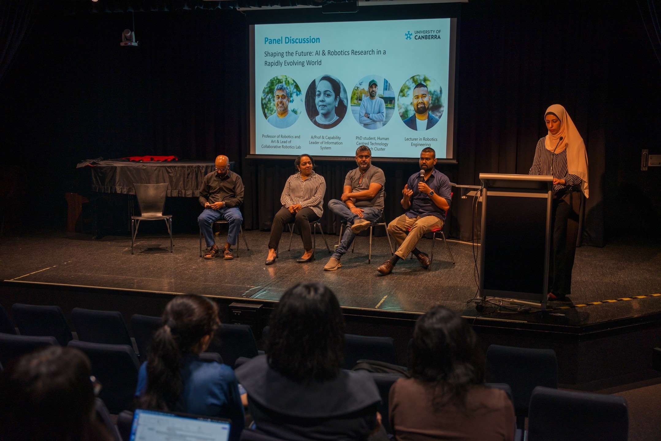 Four academics seated on stage during a panel discussion.