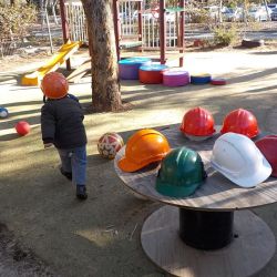 hard hats on a table, two children wearing hard hats, role playing