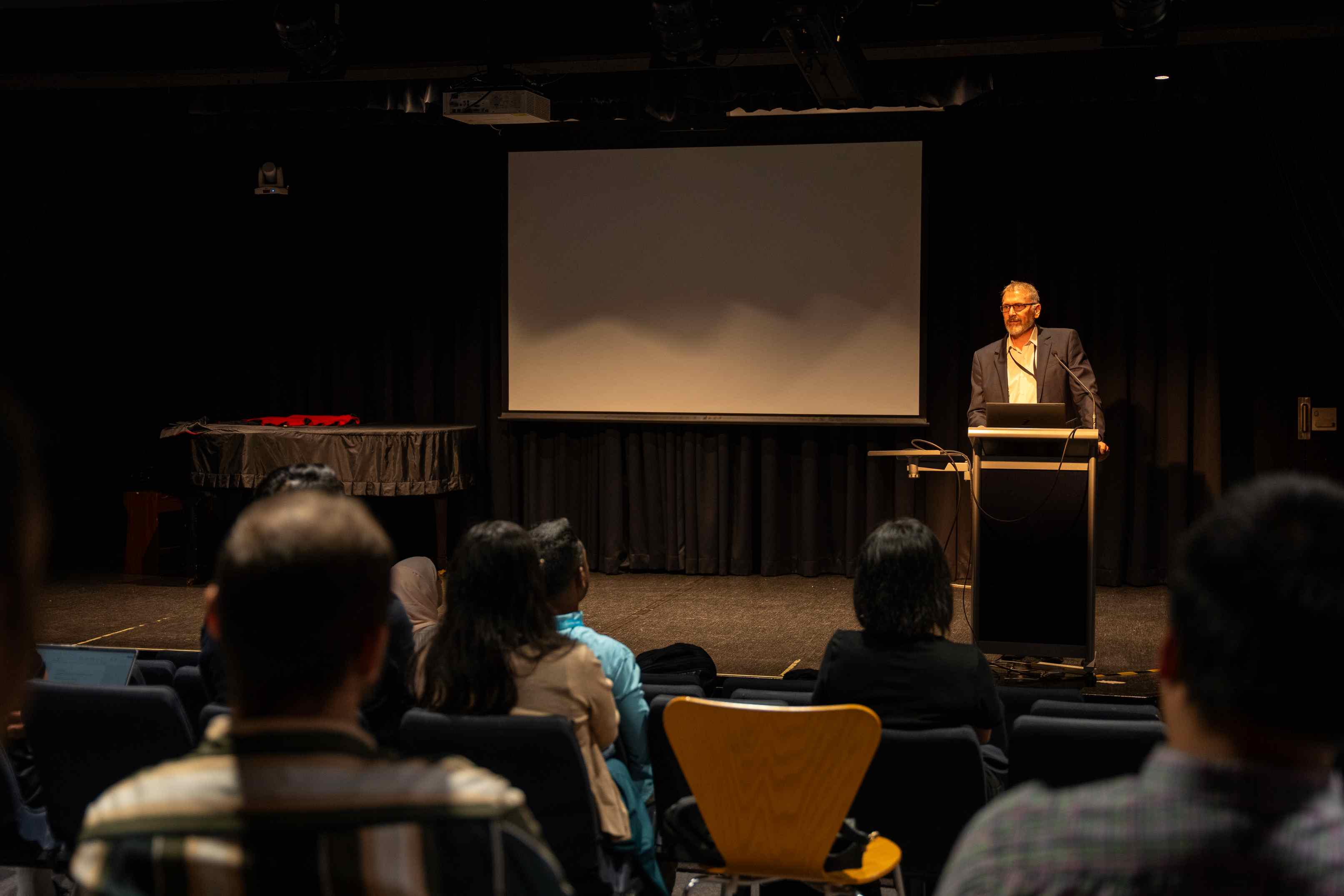 Mr. Scott Carr speaking at a podium.